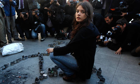 Chilean student leader Camila Vallejo sits among a peace sign created from empty teargas canisters used by police against protesters. Photograph: Roberto Candia/AP