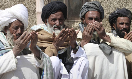 Afghan villagers during a prayer ceremony for victims of Sunday's killing of civilians, apparently by a lone US soldier, in Panjwai. Photograph: Allauddin Khan/AP