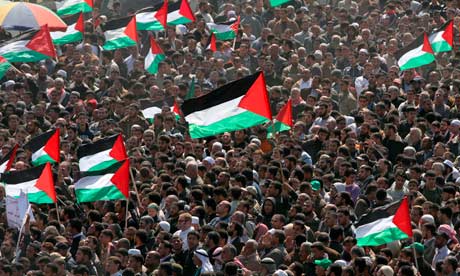 Palestinian protesters hold up their national flag as they protest close to the border between Israel and the northern Gaza Strip during Land Day demonstrations. Photograph: Mohammed Abed/AFP/Getty