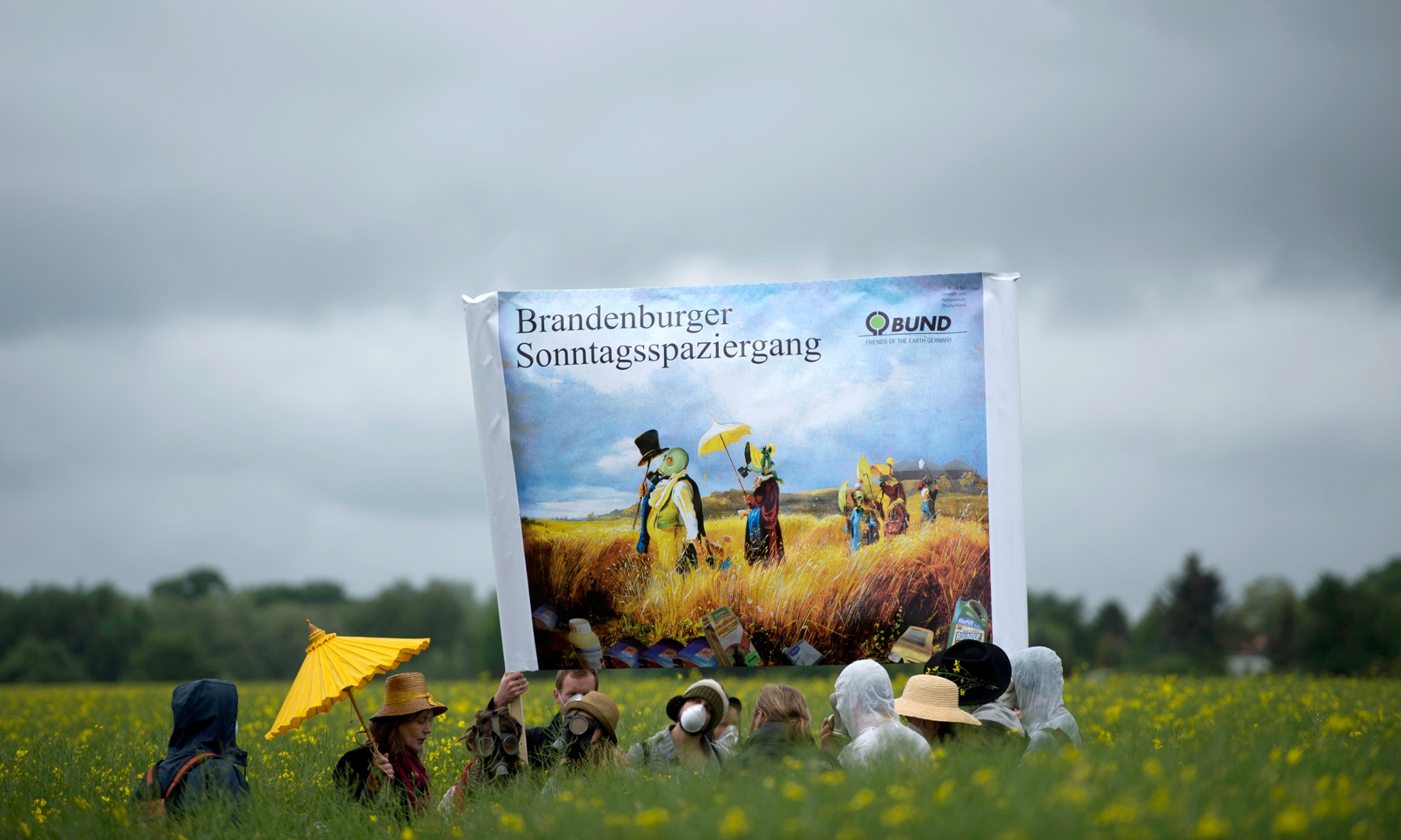 Environmental activists stand with respirator masks in a canola field during the campaign 'No poison on our fields' ('Kein Gift auf unsere Felder') near Fahrland, Germany, 22 May 2013. The acitivists fight for mandatory goals and measures for the reduction of pesticides in agriculture and demand the introduction of a tax on pesticides.